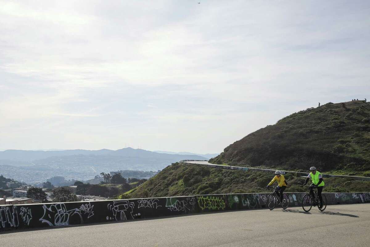 Cyclists ride through the Twin Peaks in San Francisco on Wednesday. Two lows are expected to hit the Bay Area and the rest of Northern California this weekend, beginning with widespread rain and snow on Friday.