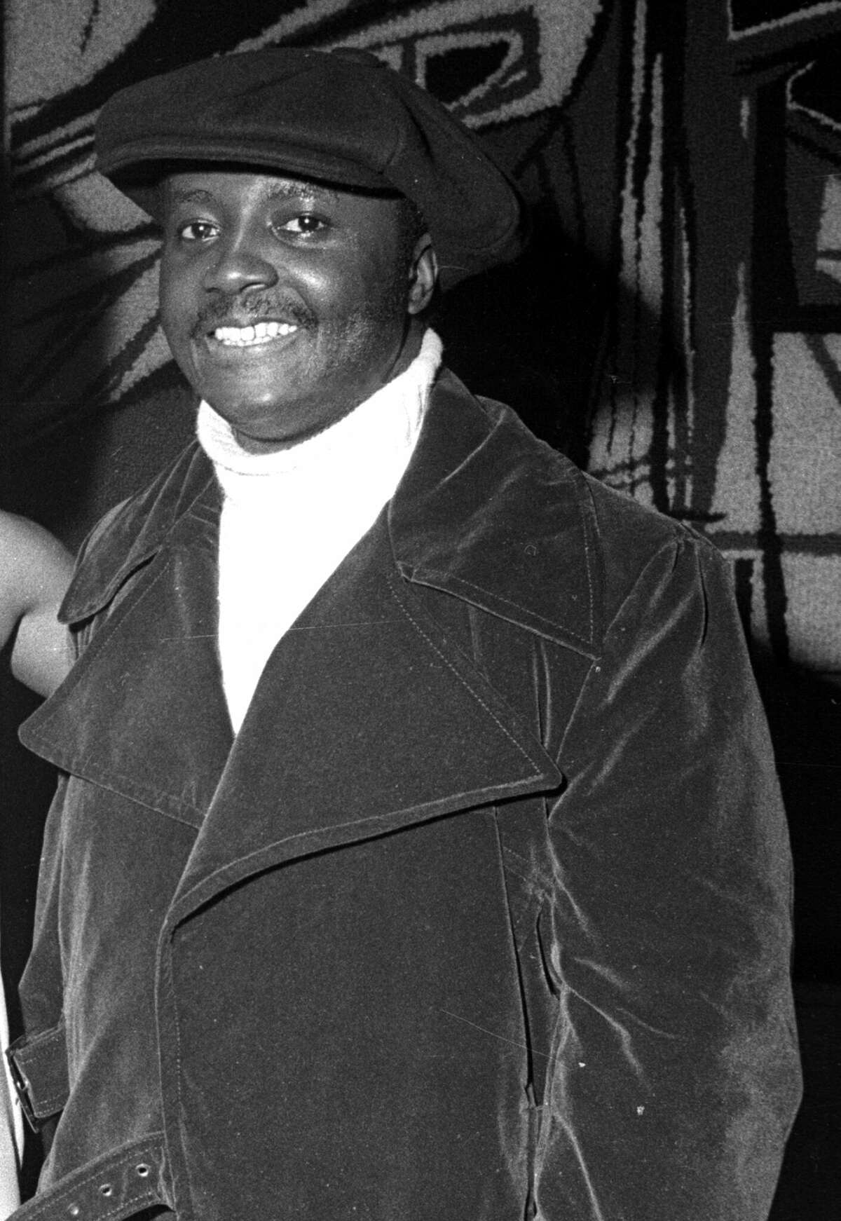 Donny Hathaway stands for the camera wearing an overcoat and cap.