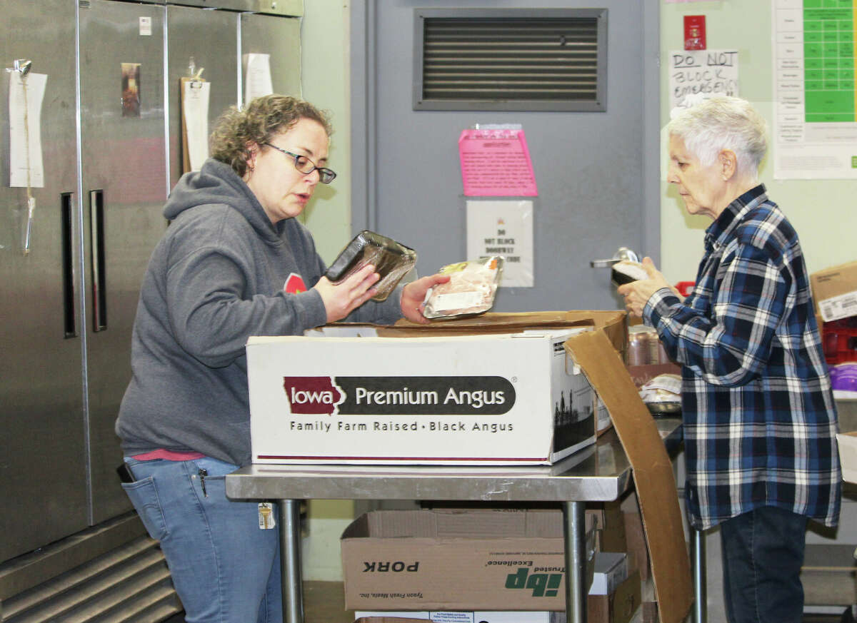 The Amazing Grace Food Pantry at 16 Stack St., a program of St. Vincent de Paul Middletown, has revamped its grocery area to make it more of a market experience for clients. Here, volunteers work behind the scenes Wednesday afternoon 
