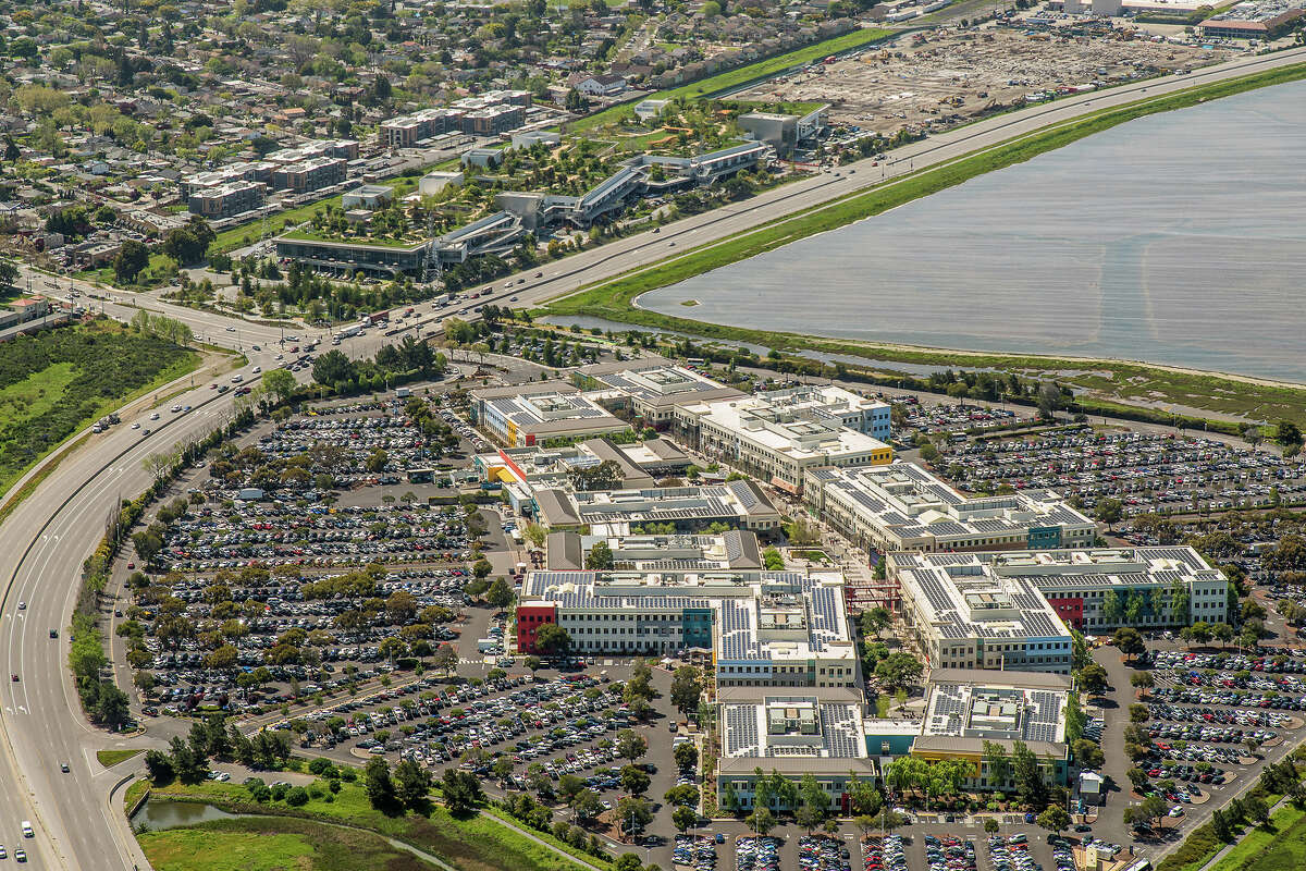 The Facebook headquarters campus is composed of two main buildings in Menlo Park next to the San Francisco Bay. The green roof building in the background was designed by Frank Gehry.