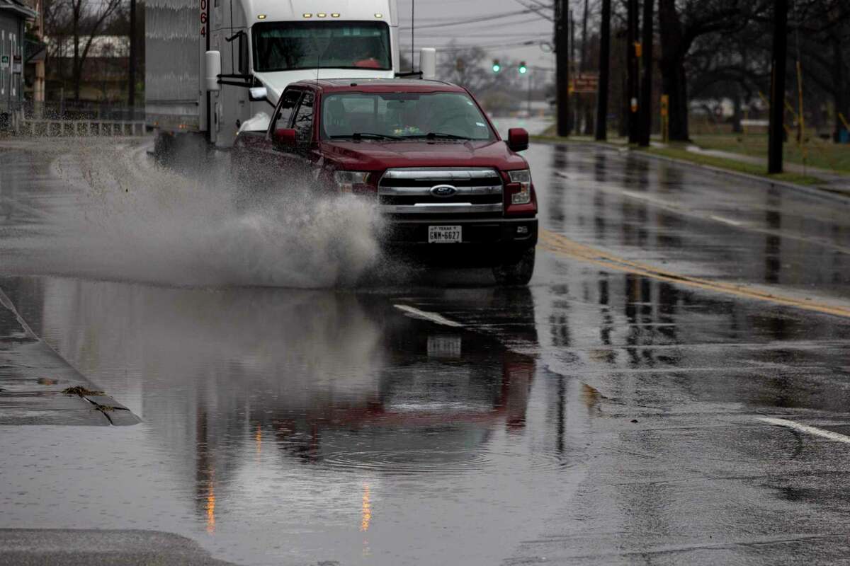 A truck skirts a large puddle along Roosevelt Avenue in San Antonio, Texas, on the morning of Feb. 1, 2023. A strong cold front blew through the area lowering temperatures into the low 30’s with ice accumulations and power outages.