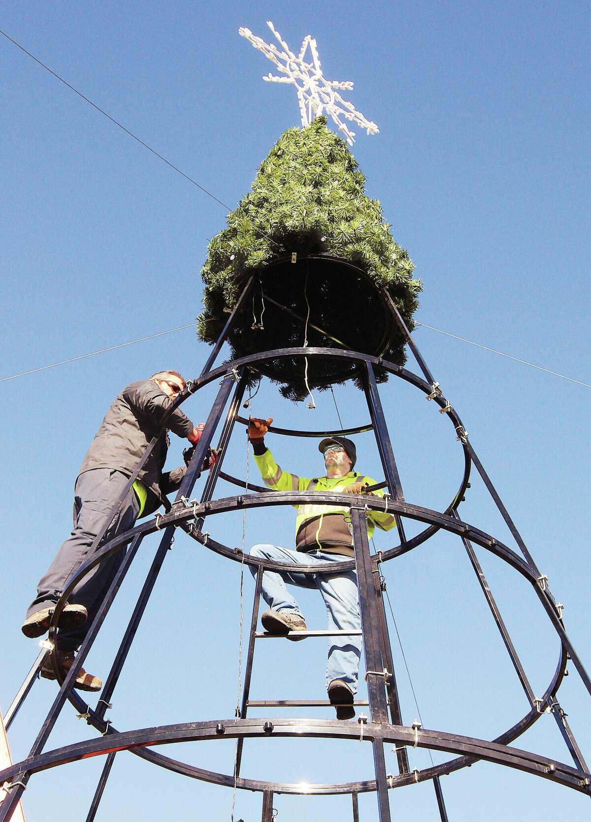 John Badman|The Telegraph Alton Parks and Recreation workers were taking down the city's second Christmas tree Tuesday morning and were down to just the topper on the tree. The tree, which was new this year, was donated for use at State House Circle next to the Rotary Centennial Fountain. The Alton-Godfrey Rotary Club disassembled the downtown Christmas tree last weekend. Both trees will be kept in storage until December.
