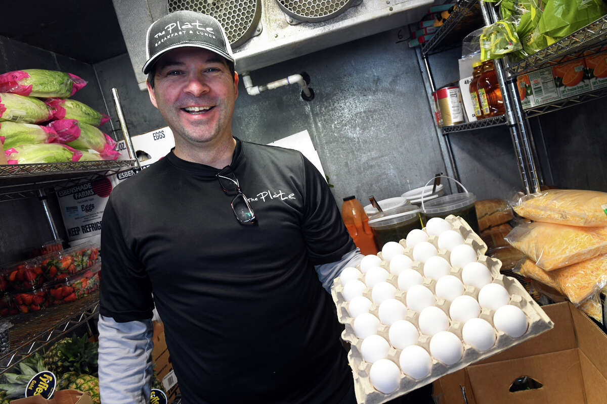 Owner and chef Ryan Trevethan poses with a carton of eggs in the walk-in cooler at The Plate, in Milford, Conn. Feb. 2, 2023.