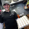 Owner and chef Ryan Trevethan poses with a carton of eggs in the walk-in cooler at The Plate, in Milford, Conn. Feb. 2, 2023.
