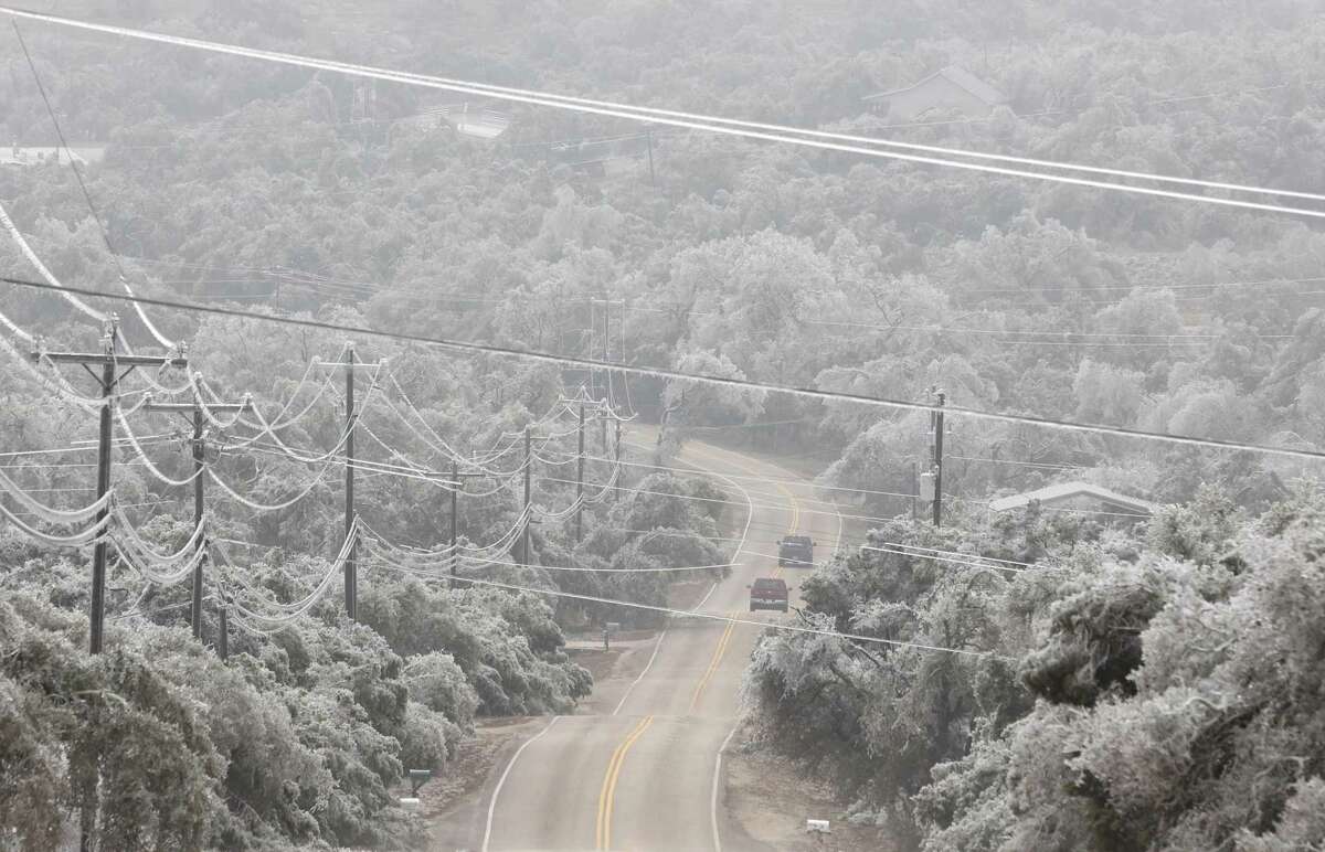 Two trucks make their way along Sun Valley Drive in Spring Branch among hillside trees covered in ice. The region suffered extensive damage to trees and other plants as a result of the ice storm over the past two days.