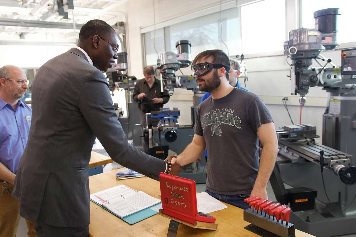 Lt. Gov. Garlin Gilchrist meets a computer numerical control machine student on Thursday at Delta College.