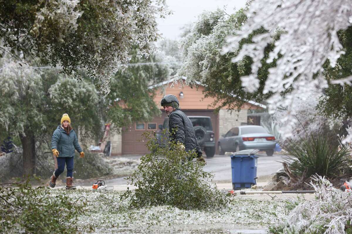 Kevin Henderson and his fiancé, Katy Allbritton, co-owners of Texas Tree Huggers, chop down tree branches at the Mead residence on Rebecca Creek Road, Thursday, Feb. 2, 2023.