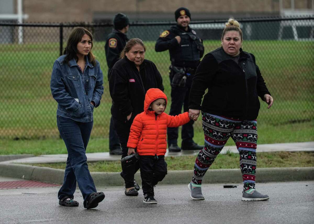 Concerned parents wait outside of Wisdom High School where police spent time searching the building after reports that a suspect ran into the building, Thursday afternoon, Feb. 2, 2023, in Houston.