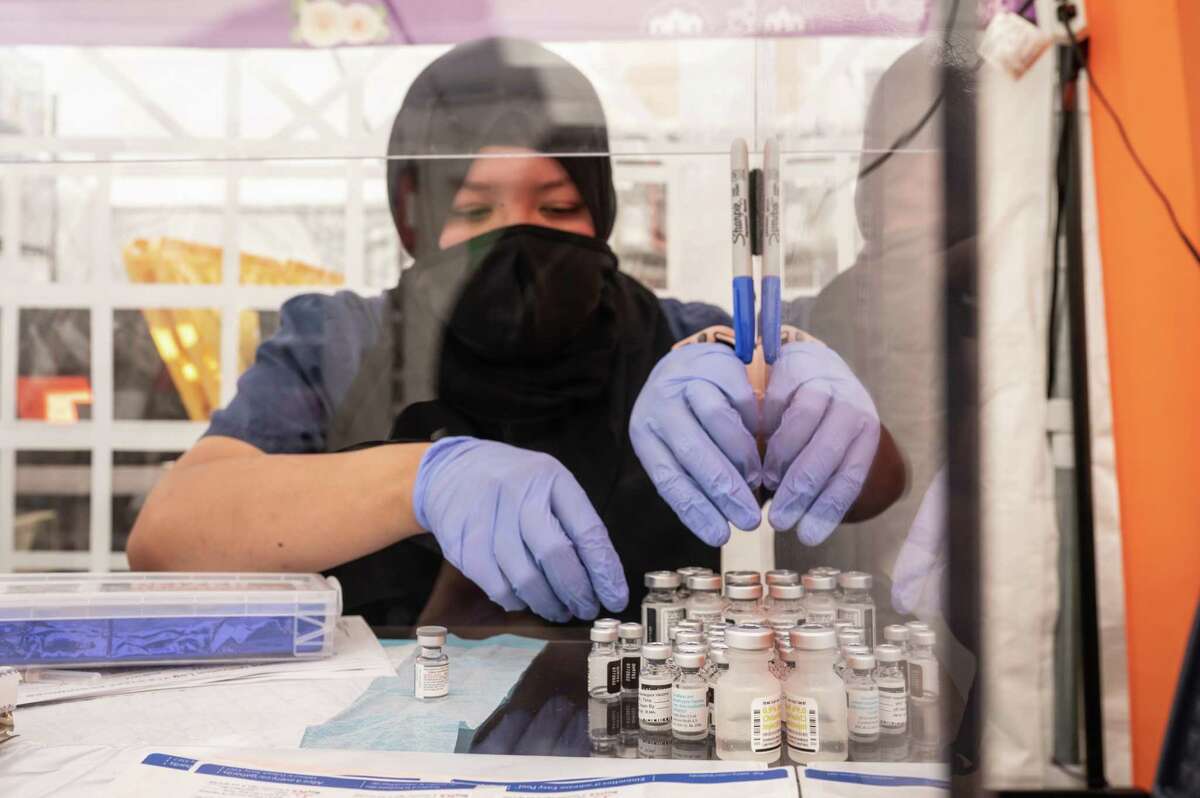 Meena Bubakar works with COVID-19 vaccines at the Unidos en Salud community clinic. Gov. Gavin Newsom's office announced $400 million in grants to strengthen the health care work force and community-level infrastructure.