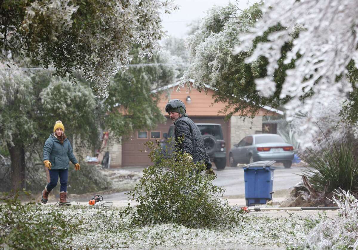 Kevin Henderson and his fiancé, Katy Allbritton, co-owners of Texas Tree Huggers, chop down tree branches at the Mead residence on Rebecca Creek Road, Thursday, Feb. 2, 2023.