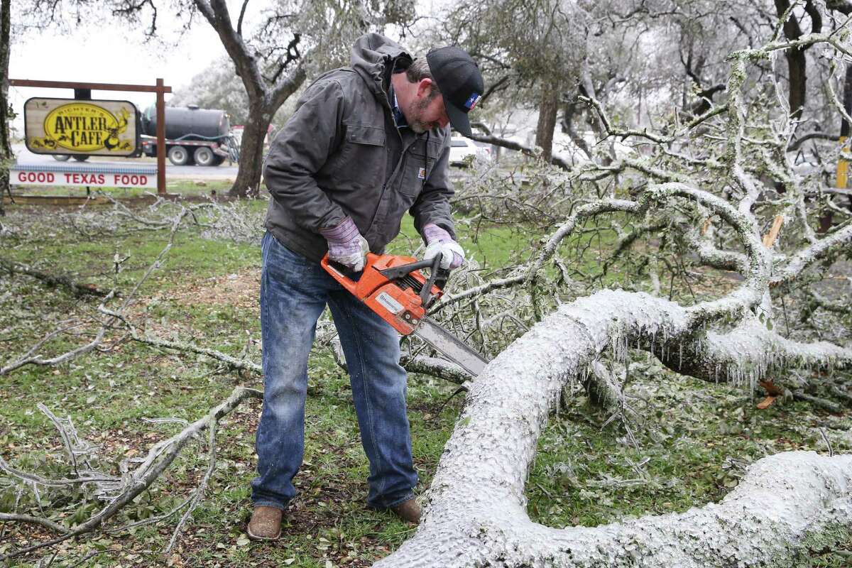 Lee Richter, owner of Richter’s Antler Café, cuts down oak tree branches at his restaurant on Texas 46 and Sun Valley Road in Bulverde, Texas, Thursday, Feb. 2, 2023. Richter said that several trees on his property lost their limbs due to the ice.