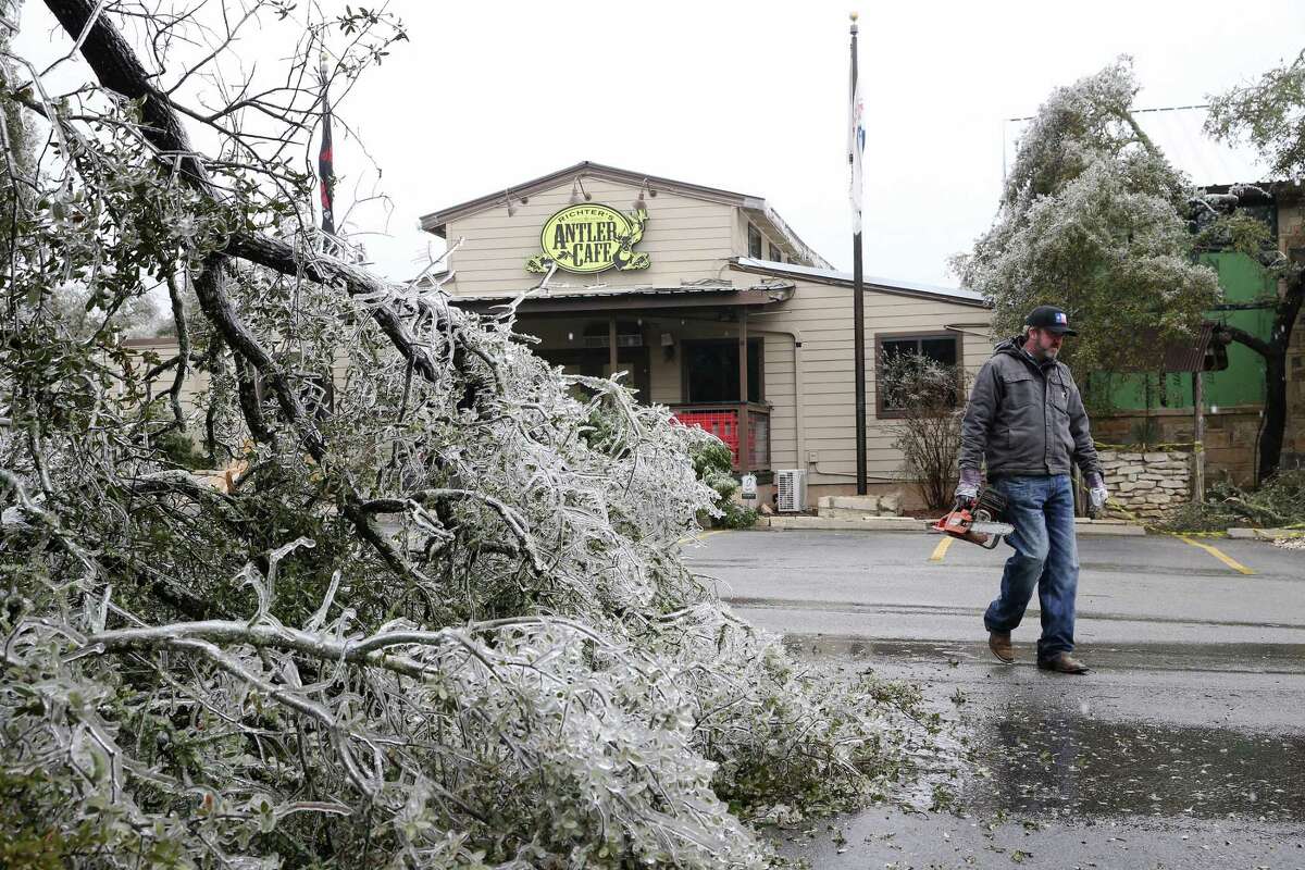 Personel remove down trees from properties in Bulverde, Texas, Thursday, Feb. 2, 2023. Trees laden with ice from a cold blast led to branches breaking off.