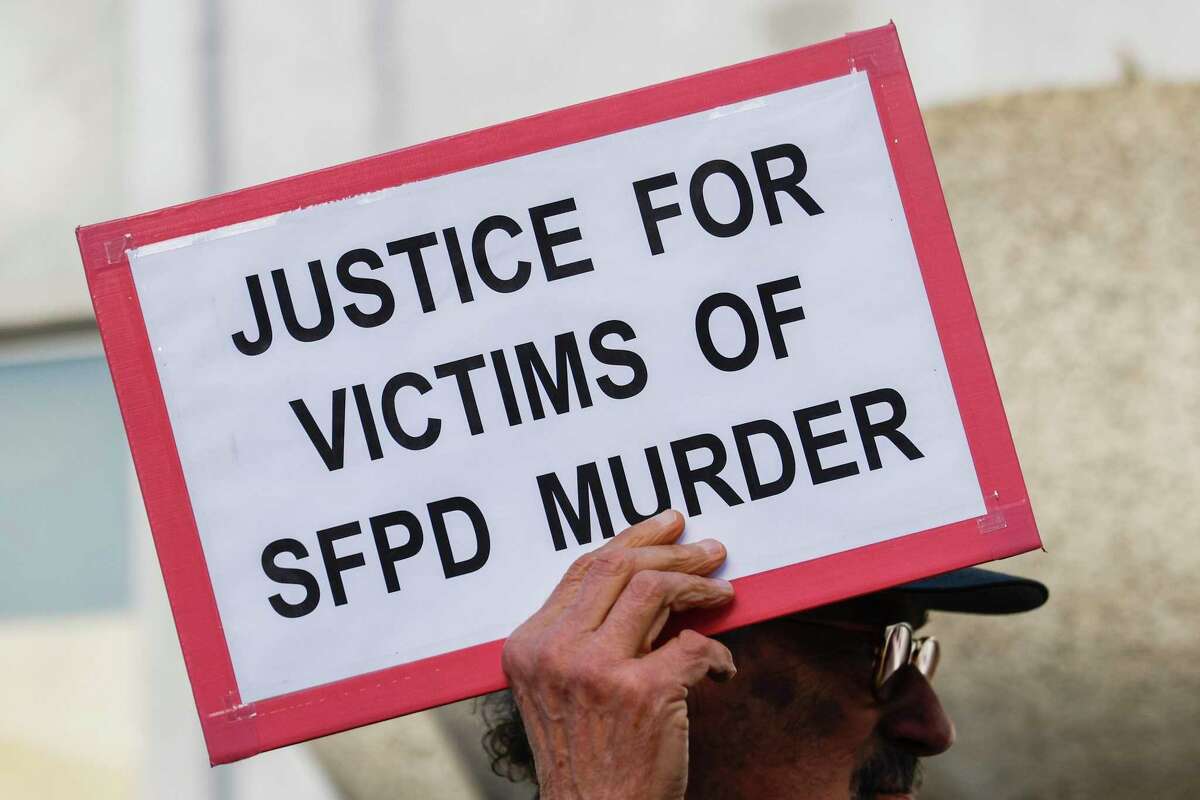A demonstrator carries a sign during a January rally outside the Hall of Justice in San Francisco in support of the families of Sean Moore and Keita O’Neil, two men of color killed by San Francisco police officers.