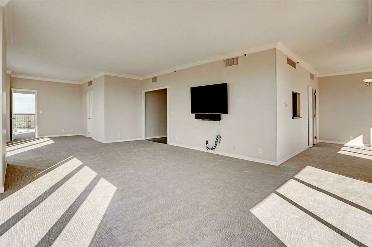 Before: the main living area was carpeted and had a TV installed on an interior wall, forcing furniture to face inward instead of taking advantage of the high-rise view. 