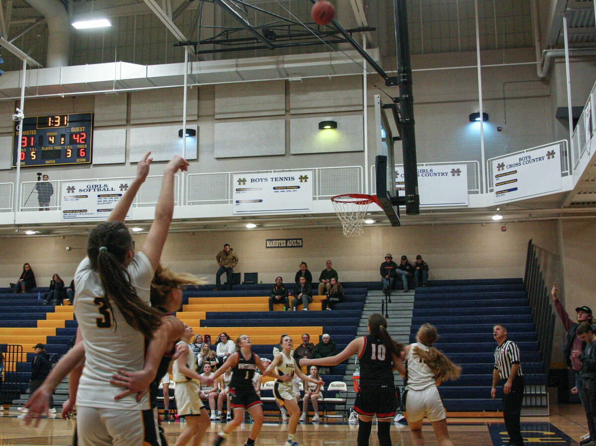 Manistee Junior Libby McCarthy (3) laucnhes a successful 3-point shot against Whitehall on Feb. 2, 2023 at Manistee High School. 