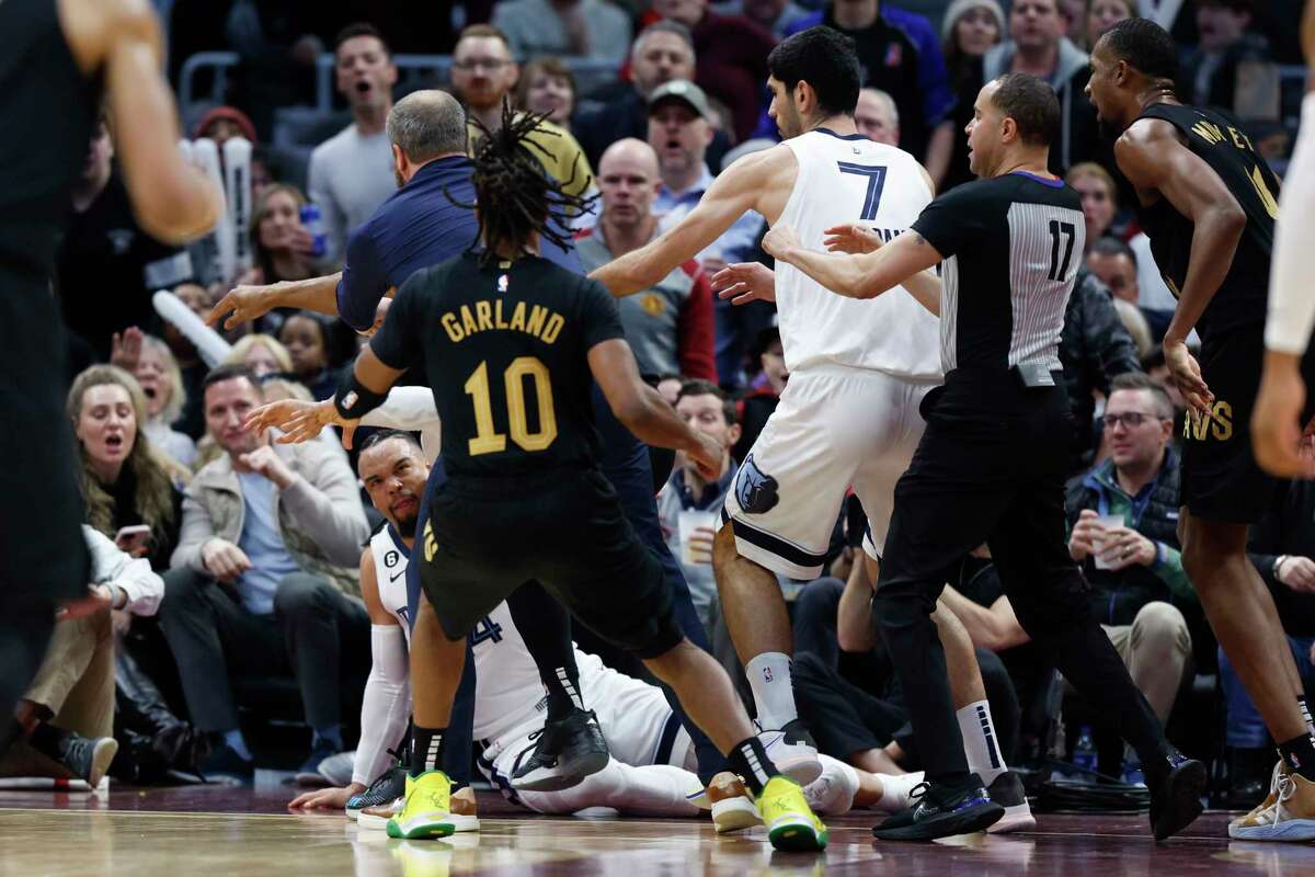 Memphis Grizzlies forward Dillon Brooks lays on the ground during a fight with Cleveland Cavaliers guard Donovan Mitchell (45) during the second half of an NBA basketball game, Thursday, Feb. 2, 2023, in Cleveland. Mitchell and Brooks were ejected from the game.