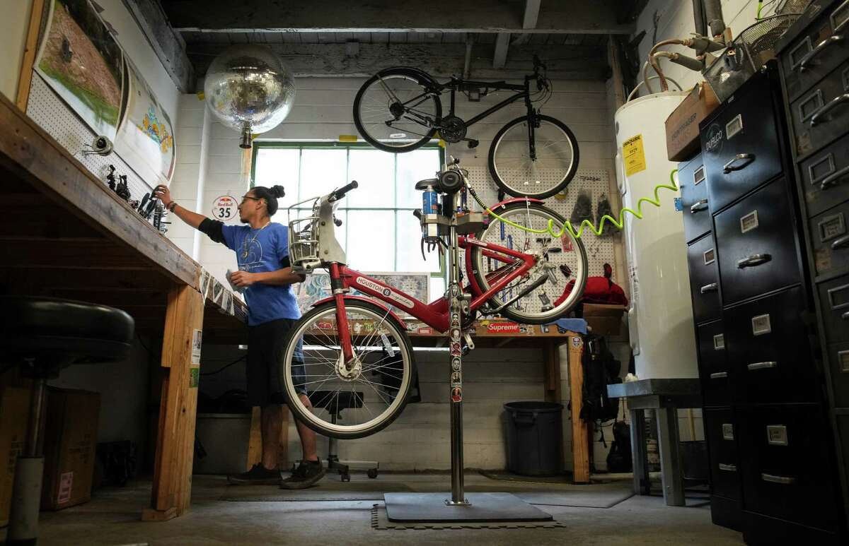 Ramon Mares, a bike mechanic, repairs a bicycle Wednesday, Feb. 1, 2023, at the Houston Bike Share office in Houston.