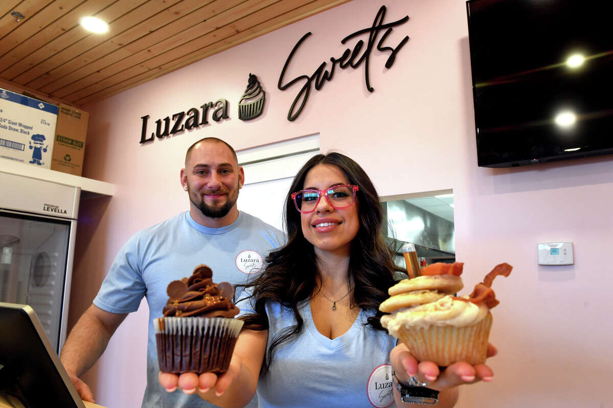 Sarah Luz Laffitte-DePalmer and her husband, James DePalmer, pose with a couple of the cupcake samples that will be available at Luzara Sweets, opening soon in Shelton, Conn., Feb. 3, 2023.