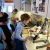 Kim Klopstock, left, lets out a laugh as she coaches grandchildren; Johnsie Parker Hedgpeth, 8, left, Leila Hedgpeth, 10, center, and Teddy, 5, right, on how to cook their breakfast on Friday, Feb. 3, 2023, at the Hedgpeth home in Greenfield Center, N.Y.
