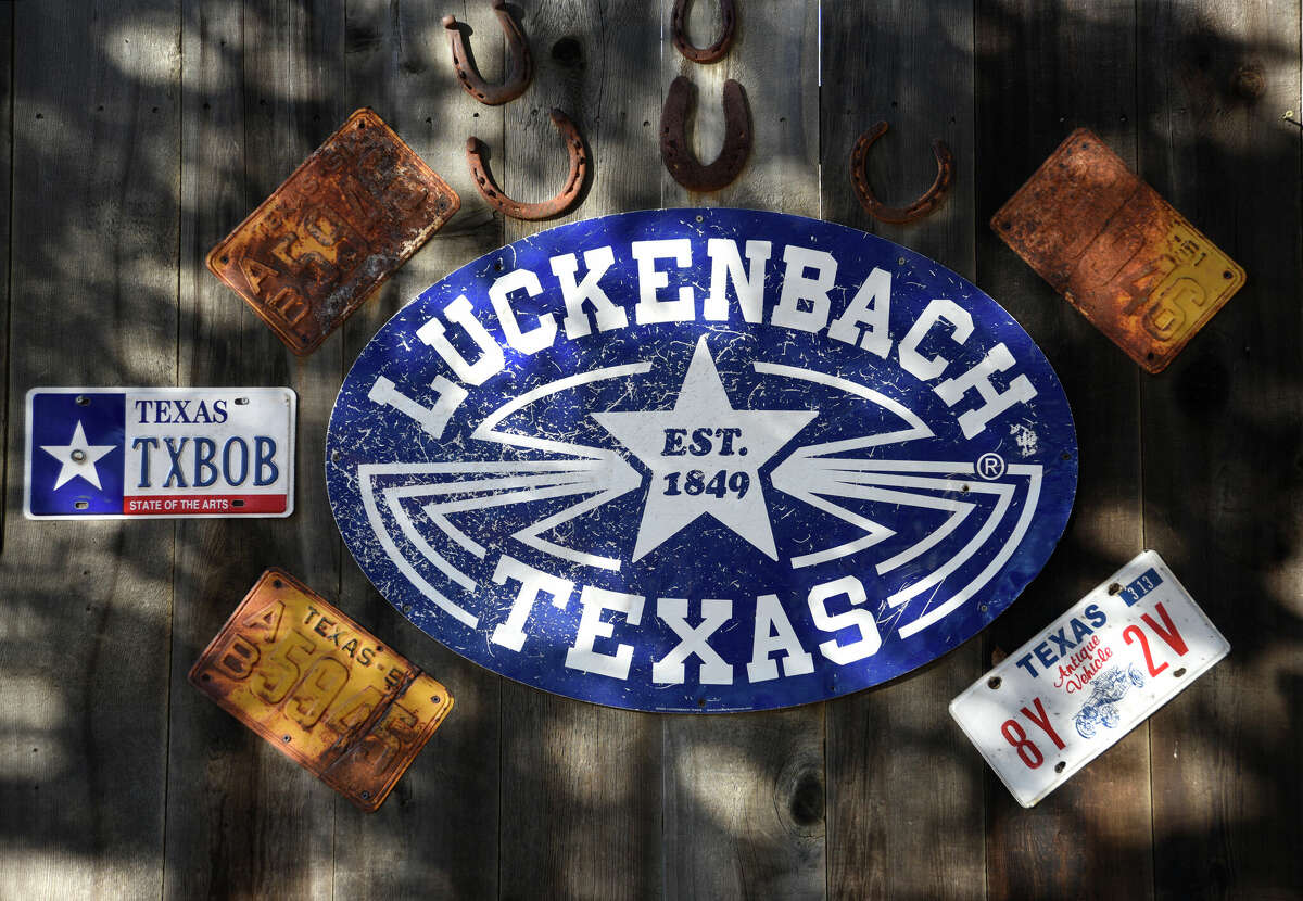 A sign and Texas automobile license plates adorn a building in Luckenbach, Texas, a popular live country music venue and tourist attraction in the Texas Hill Country. 