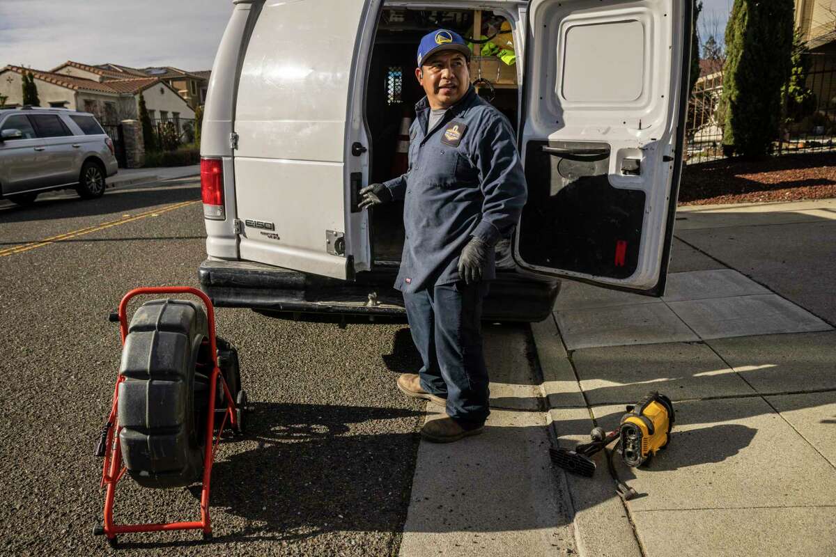 Jose Ramos, a plumber with Oakland Rooter Plumbing Co., gets ready to load pipe inspection equipment in his work van after performing an inspection in Oakland.