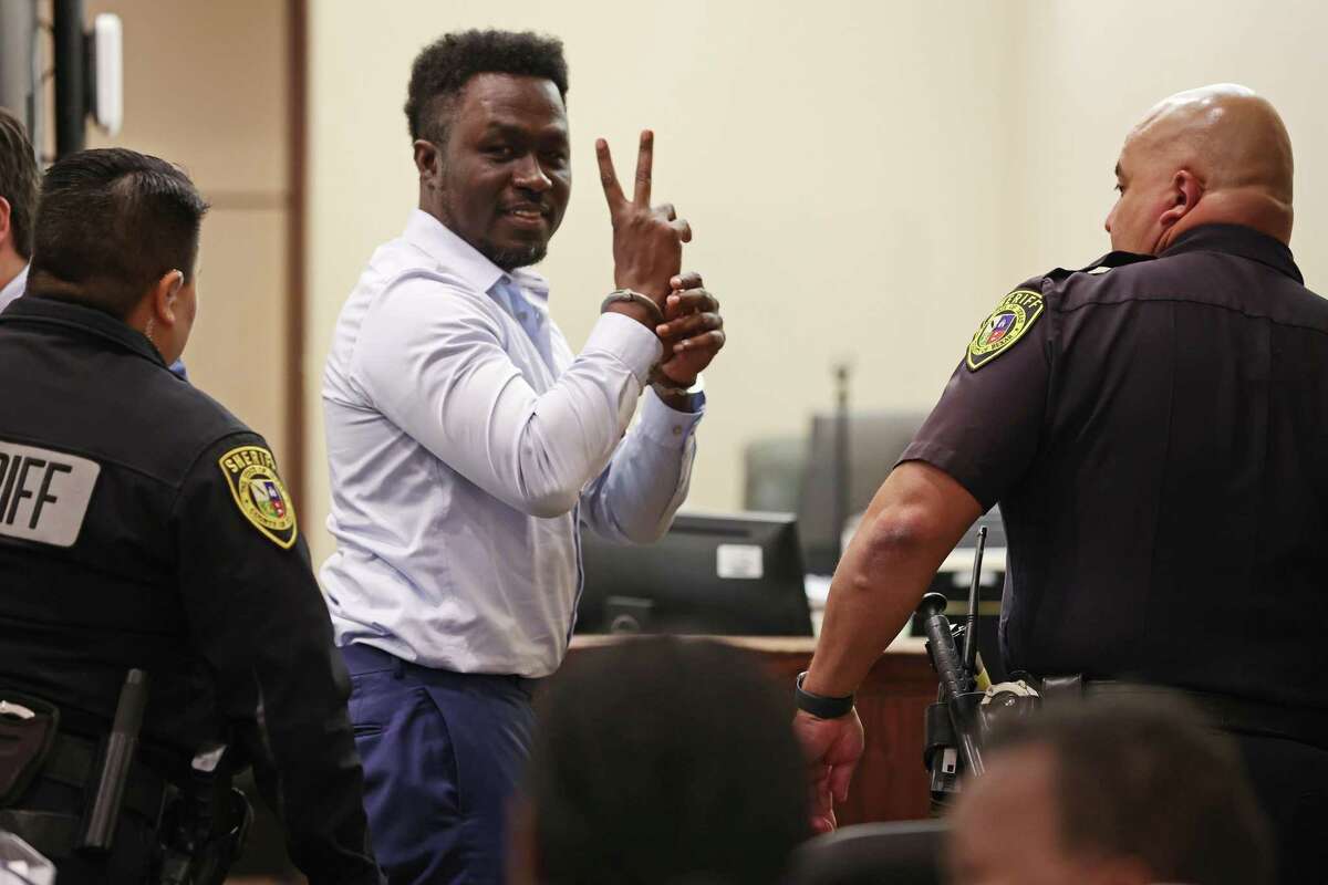 Andre McDonald holds up two fingers in a “V” shape as he looks toward his family members in the courtroom after being found guilty of manslaughter, not murder, on Friday, Feb. 3, 2023.