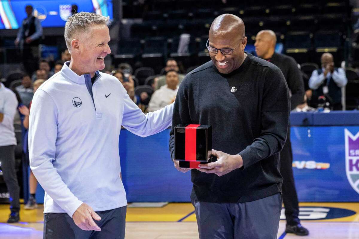 Sacramento Kings Head Coach Mike Brown, right, reacts after he was presented his 2022 NBA champion ring by Golden State Warriors Head Coach Steve Kerr before their NBA basketball game in San Francisco, Calif. Sunday, Oct. 23, 2022.