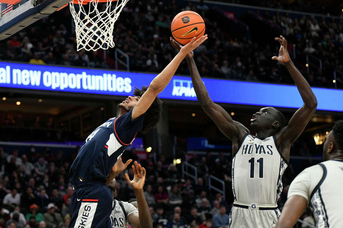Connecticut guard Andre Jackson Jr., left, battles for the ball against Georgetown forward Akok Akok (11) during the first half of an NCAA college basketball game, Saturday, Feb. 4, 2023, in Washington. (AP Photo/Nick Wass)