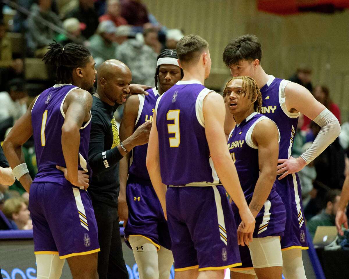 UAlbany coach Dwayne Killings, second from left, speaks to his players on the court as Vermont takes a foul shot during a game at McDonough Sports Complex on Saturday, Feb. 4, 2023. The Danes had to play on Hudson Valley Community College's court because of renovations to SEFCU Arena and couldn't overcome injuries in a trying season.