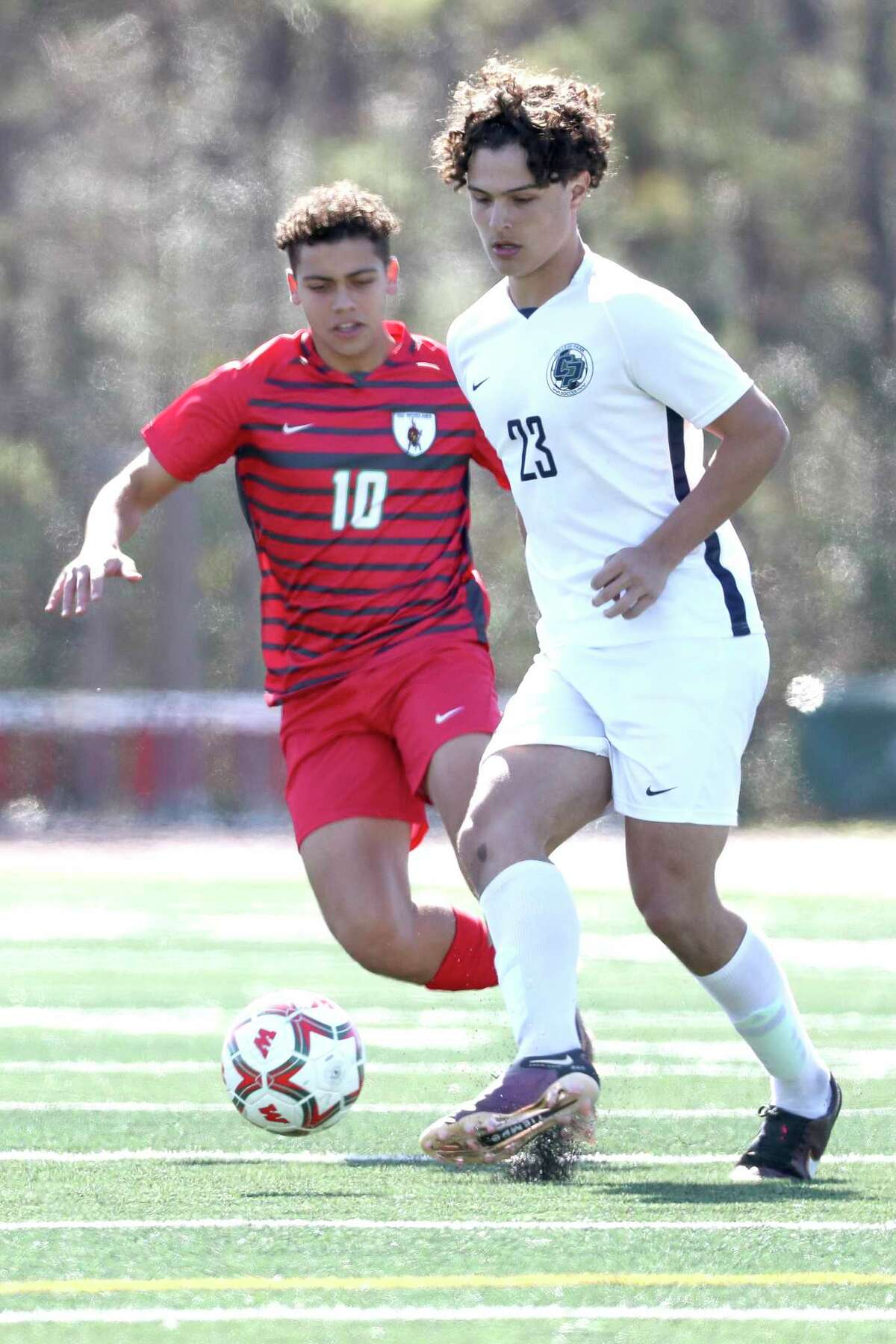 College Park's Julio De Los Reyes (23) makes a pass as The Woodlands' Henrique Caputo (10) defends during a District 13-6A high school soccer match at The Woodlands High School, Saturday, Feb. 4, 2023, in The Woodlands.