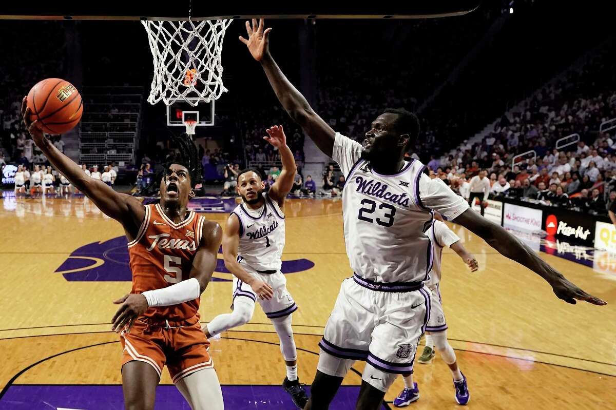 Texas guard Marcus Carr (5) shoots under pressure from Kansas State center Abayomi Iyiola (23) during the first half of an NCAA college basketball game Saturday, Feb. 4, 2023, in Manhattan, Kan.