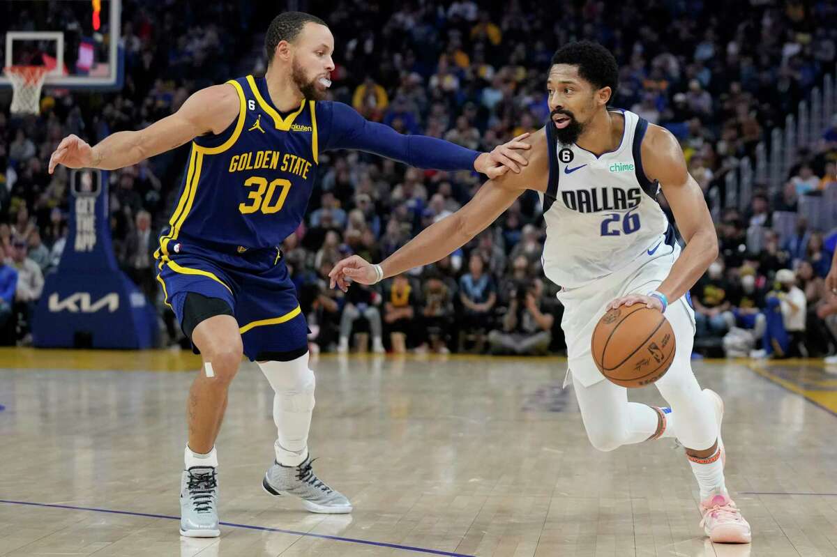 Dallas Mavericks guard Spencer Dinwiddie (26) drives to the basket against Golden State Warriors guard Stephen Curry (30) during the first half of an NBA basketball game in San Francisco, Saturday, Feb. 4, 2023. (AP Photo/Jeff Chiu)