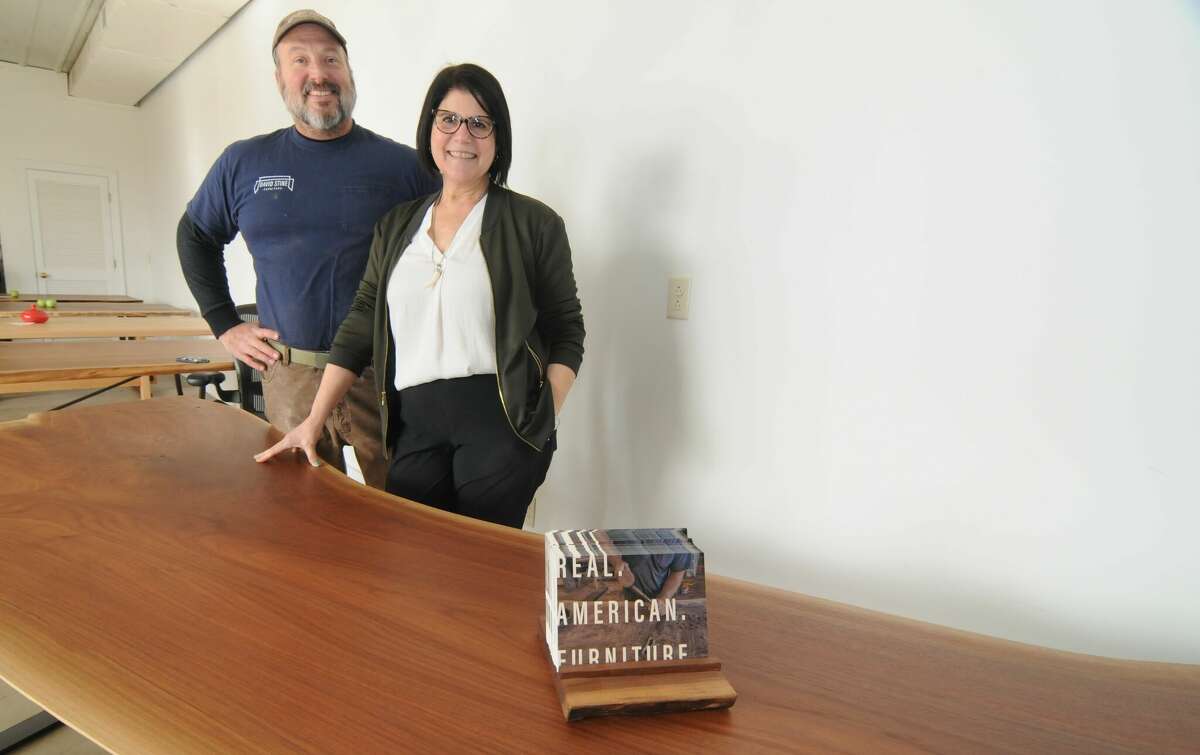 David Stine and Stephanie Abbajay, the husband-and-wife owners and operators of David Stine Furniture, stand by a live-edge desk in the business' Dow showroom.    