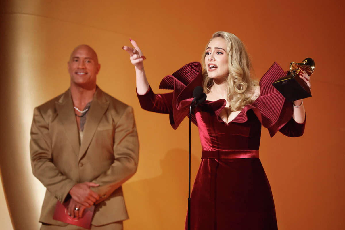 LOS ANGELES, CALIFORNIA - FEBRUARY 05: (FOR EDITORIAL USE ONLY) (L-R) Dwayne Johnson and Adele, winner of the Best Pop Solo Performance award for “Easy On Me,” speak onstage during the 65th GRAMMY Awards at Crypto.com Arena on February 05, 2023 in Los Angeles, California.