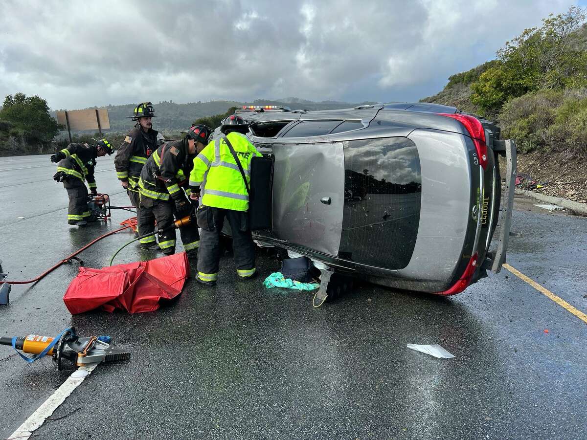Emergency personnel work to extricate three people from an SUV on I-280 Sunday morning.