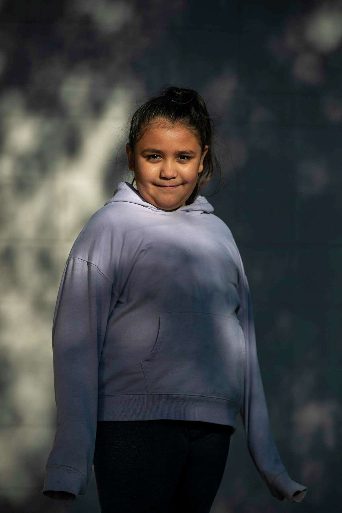 Sofia Lopez, 8, poses in evening light at Hondo Recreation Park last week. In November, a coach brought his hand to the back of Sofia’s head in gym class at Woolls Intermediate School, which made her anxious about going to school. Her parents called it an assault. The school district says it was a pat of encouragement.