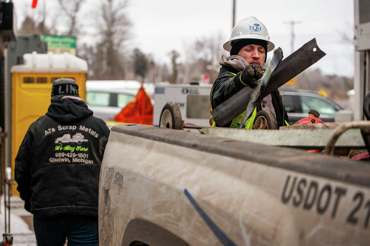 EPA clean-up technician Quentin Radue tosses scrap metal into a truck on Feb. 6, 2023 in Edenville.