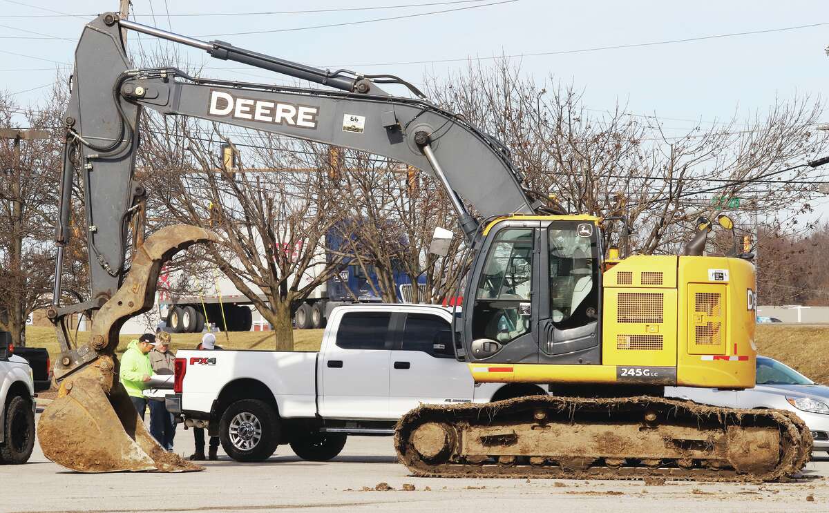 John Badman|The Telegraph Workers were using the back of a pickup truck Monday to look over plans for a Starbucks to be built at 1725 Homer Adams Parkway in Alton where heavy equipment was unloaded.