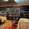 Servers user laser pointers to highlight where cuts of meat originate on a pig, vow and lamb at Iron & Grass, a nose-to-tail chophouse in former school building about 5 miles southeast of downtown Hudson.