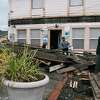 达伦·加拉格尔(左后)与一名邻居一起拆除由于2022年12月20日地震而从他的里约热内卢戴尔(洪堡县)房子前面掉下来的阳台。
