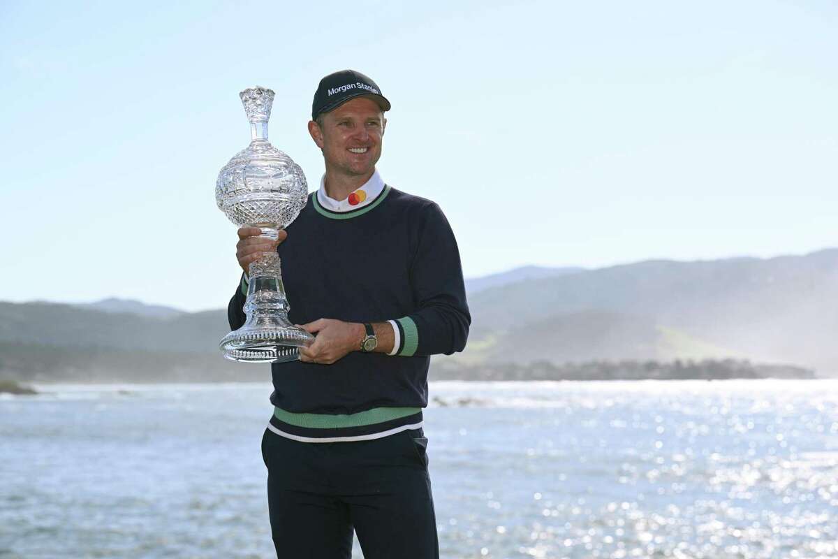 PEBBLE BEACH, CALIFORNIA - FEBRUARY 06: Justin Rose of England poses with the trophy on the 18th hole after victory during the continuation of the final round of the AT&T Pebble Beach Pro-Am at Pebble Beach Golf Links on February 06, 2023 in Pebble Beach, California. (Photo by Orlando Ramirez/Getty Images)