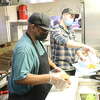 Chuck's Sandwich Shop employees Guy Antoine, front, and Aaron Lafayette prepare lunch orders on Wednesday, Feb. 1, 2023.
