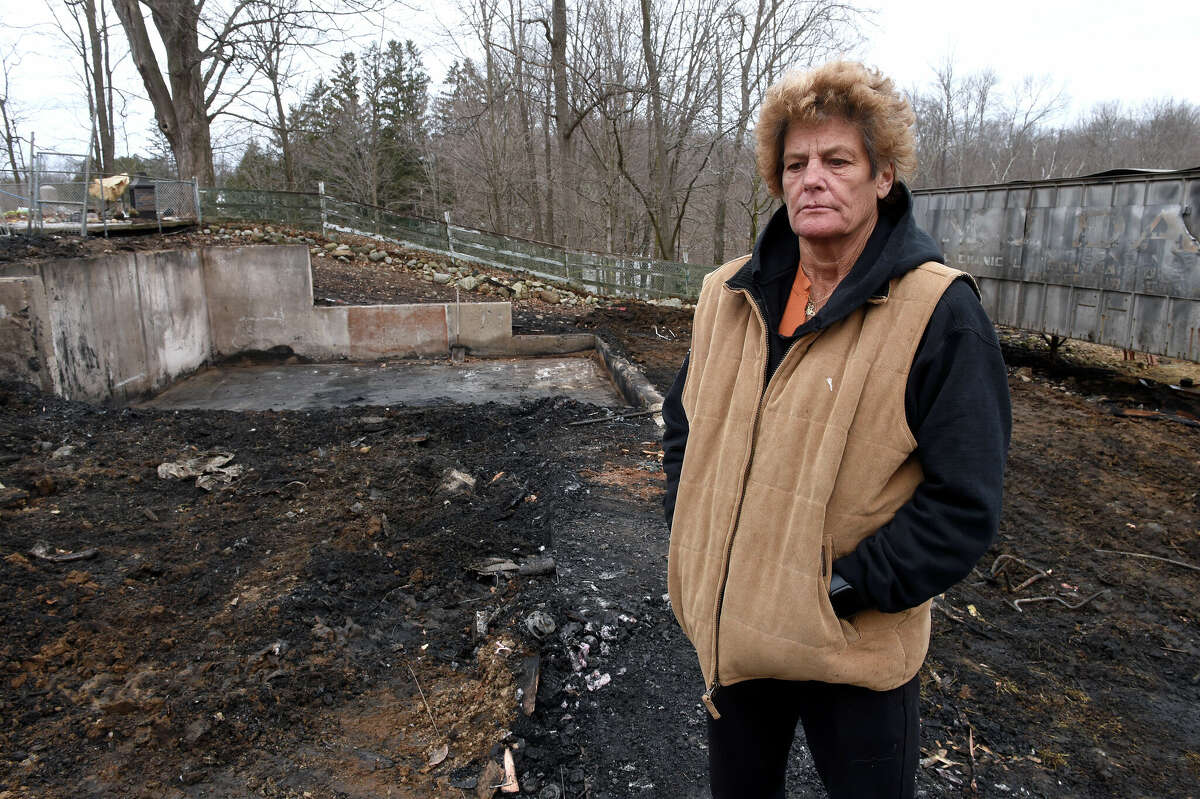 Kelly Cronin, executive director of Kelly's Kids Inc, stands by the foundation from where her burned down barn stood behind her home in Prospect on February 6, 2023.