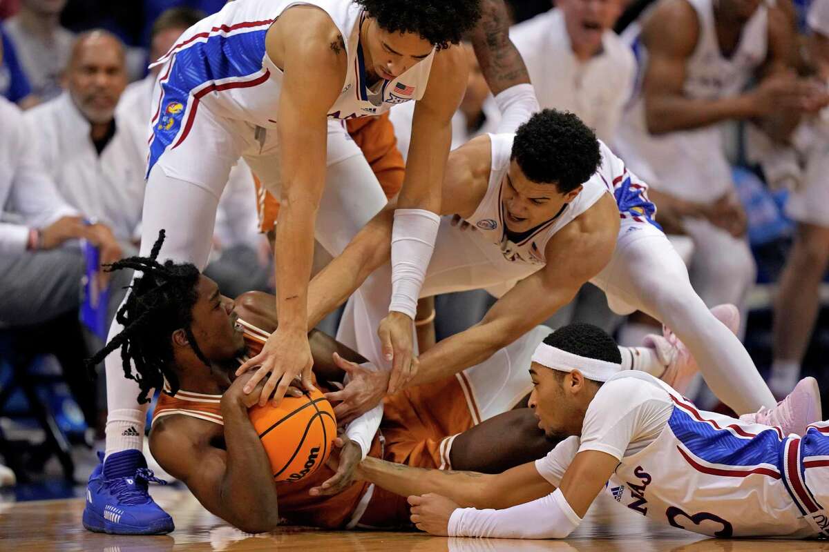 Texas guard Marcus Carr, bottom, scored 29 points to lead the fifth-ranked Longhorns, but his team came up short on the road in an 88-80 loss to No. 9 Kansas.
