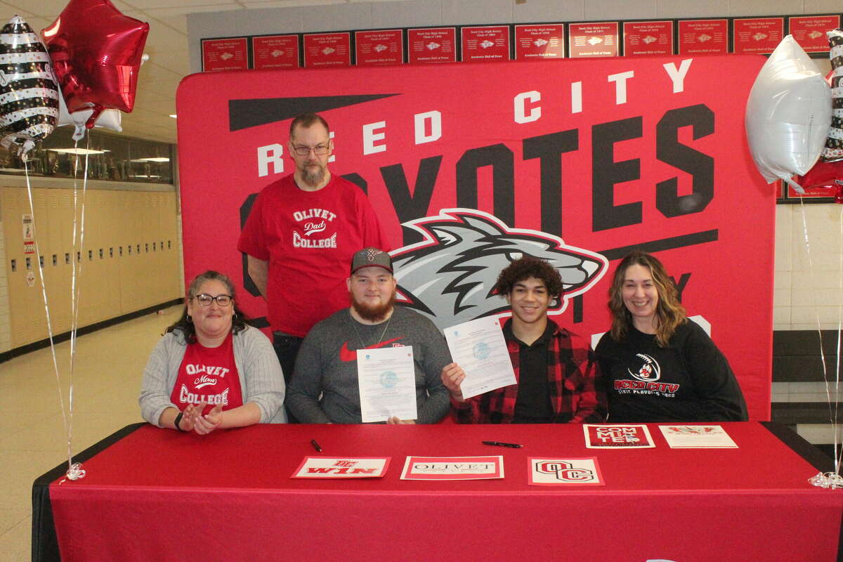 Kyle Crusan (second from left) and Bryson Hughes (second from right) show their letters of intent they signed on Monday to play football at Olivet College. At left are Kyle's parents, Robert and Ember Crusan, and at right is Hughes' mother, Cathy Baker.