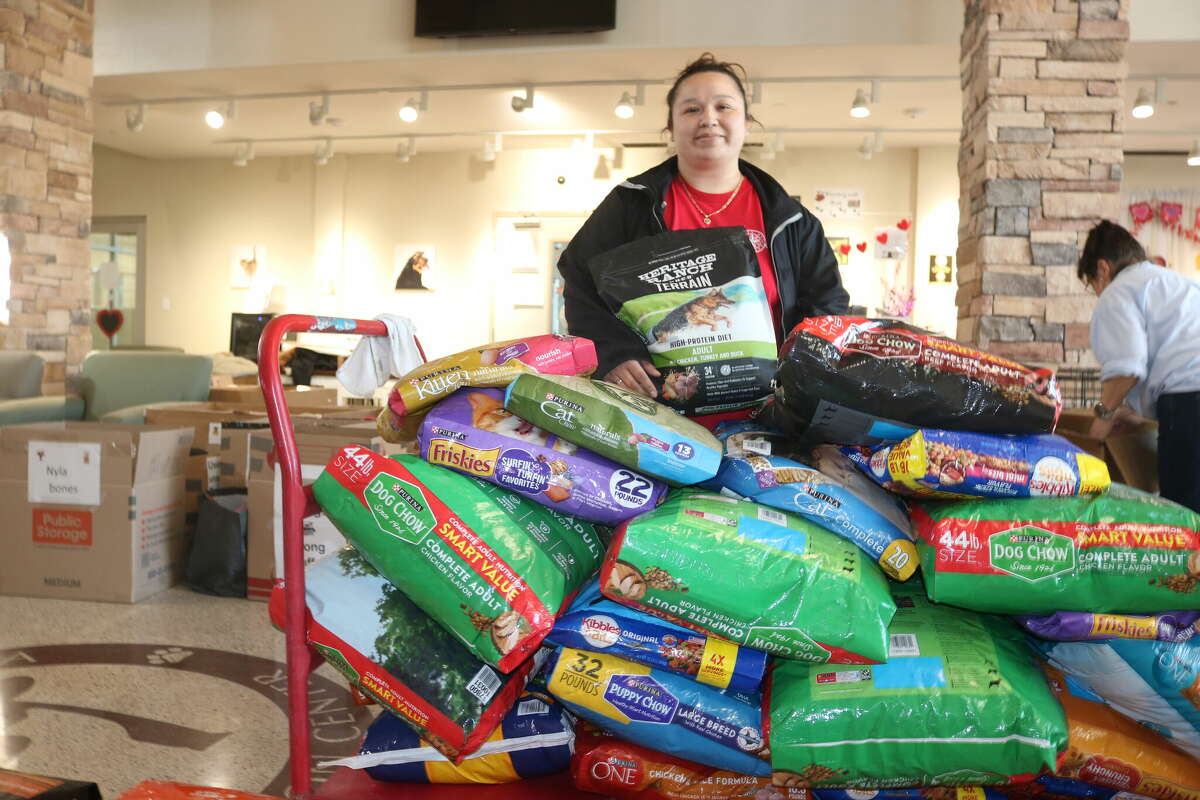 Johana Murillo, assistant manager for the Pasadena Animal Control & Adoption, stands behind a dolly filled with newly-donated food that was dropped off Monday afternoon.