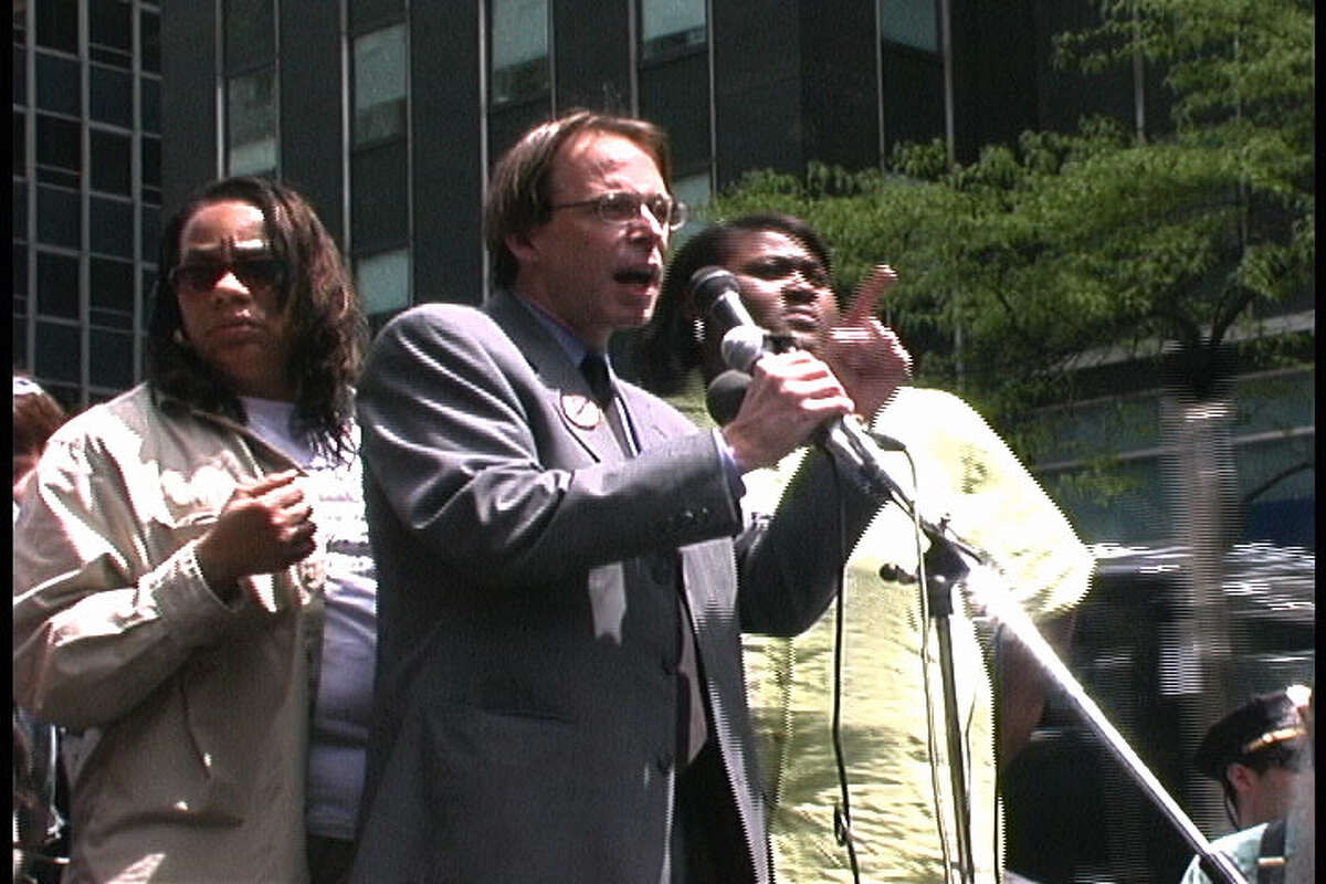 Jeff Blackburn speaks at a rally in New York City in 2002. Tonya White, who was wrongfully accused of selling drugs in Tulia, Texas in 1999, stands to his left.