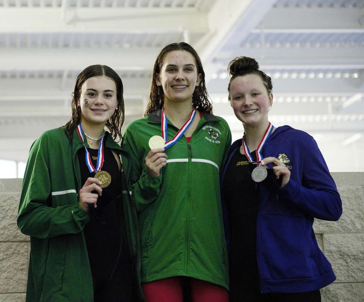 Midland High freshman Hannah Krueger, right, poses with her silver medal on the podium after finishing second in the girls 100-yard freestyle final at the Region I-6A Swimming & Diving Championships, Feb. 7 at COM Aquatics. Southlake Carroll's Marin Clem (center) and Olivia Columbo (left). 