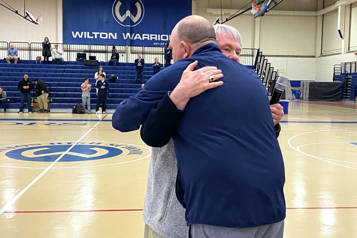 Franey Donovan hugs Wilton basketball coach Joel Geriak after being honored for 30 years calling games at Wilton.