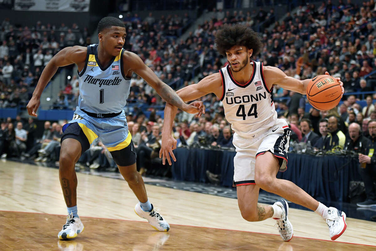 UConn's Andre Jackson Jr. (44) dribbles as Marquette's Kam Jones (1) defends in the second half of an NCAA college basketball game, Tuesday, Feb. 7, 2023, in Hartford, Conn. (AP Photo/Jessica Hill)